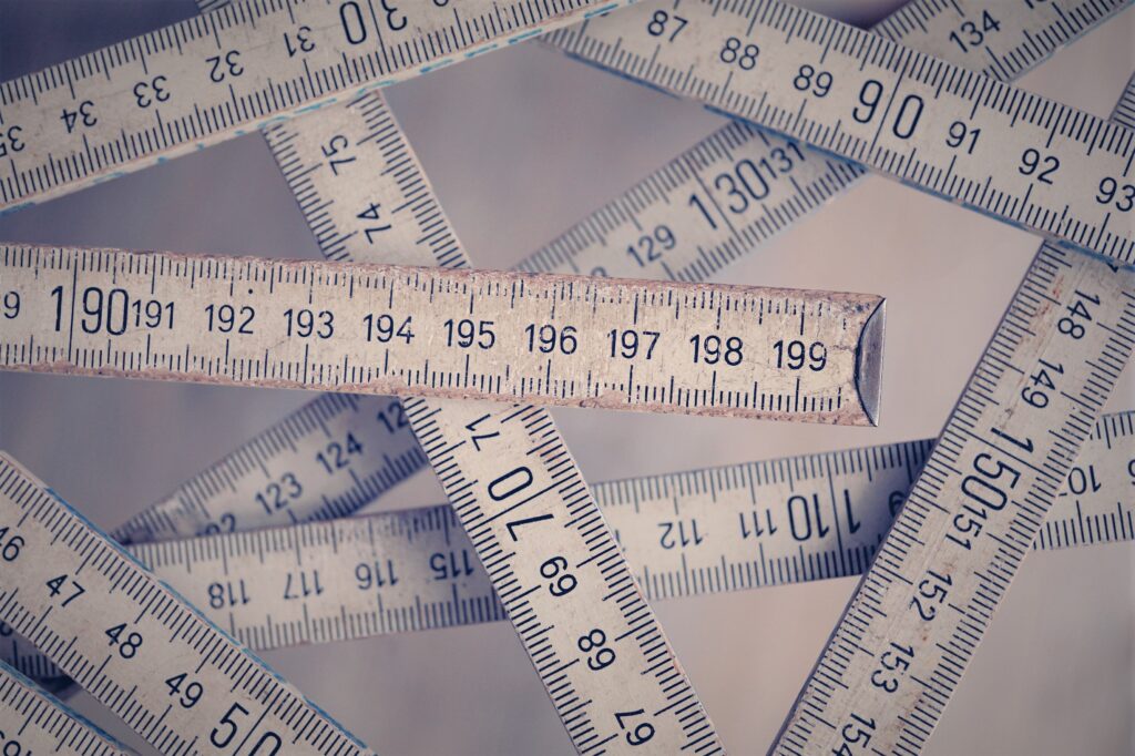 A collection of vintage folding rulers measuring in centimeters on a neutral background.
